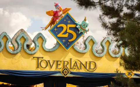 Bunte Figuren feiern 25 Jahre Toverland Freizeitpark. Ein Papagei und ein Oktopus zieren das Jubiläumslogo über dem Eingang.