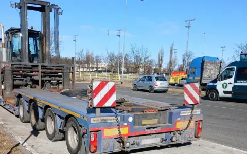 Ciężarówka z naczepą przewozi wózek widłowy. To przykład pojazdu nienormatywnego, który wymaga specjalnych zezwoleń.