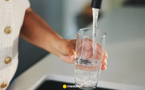 Ręka nalewa wodę do szklanki. Zastanawiasz się, kiedy skończy się woda pitna? Dbajmy o zasoby.