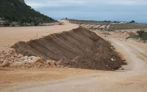 Un terraplén, parte de una obra vial, se eleva con tierra removida. El terraplén significado es la elevación artificial del terreno.