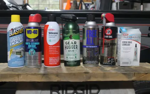 A collection of garage door lube and other lubricants, including Blaster, WD-40, Dupont Silicone, Gear Hugger, Free All, 3-in-One, and Genie Screw Drive Lubricant.