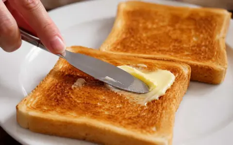 Goldbraunes Brot im Ofen getoastet, wird nun mit Butter bestrichen. Ein Genuss!