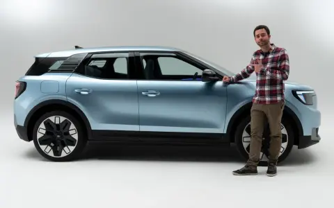 Hombre junto a un coche azul claro, mostrando las medidas del Ford Explorer.