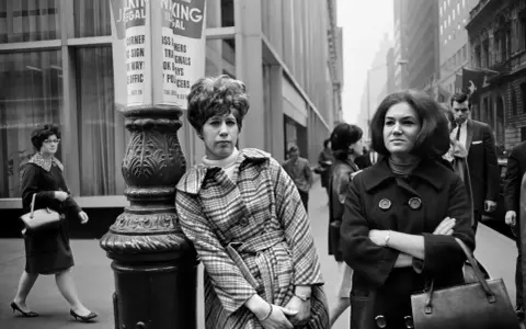 Donne in strada, stile anni '60, un'istantanea che ricorda Stephen Shore.