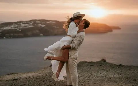 Pareja besándose al atardecer, ella en brazos de él, con un aire de bodas ibicencas.