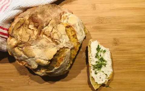Ein rustikales, frisch gebackenes italienisches Brot Rezept, das genial einfach ist. Daneben ein Stück Brot mit Frischkäse und Kresse.