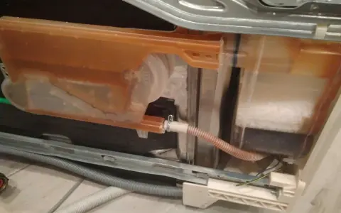 Zmywarka Electrolux z błędem i20. Widoczny zbiornik z brązową wodą i solą.