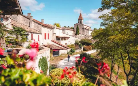Un homme se promène dans un village pittoresque du Tarn-et-Garonne, une belle activité en plein air.
