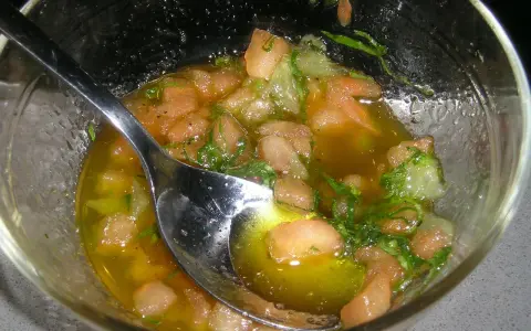 Sauce vierge fraîche avec des dés de tomate, des herbes et de l'huile d'olive, prête à accompagner un poisson.