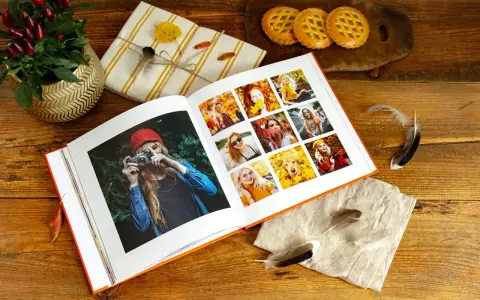 Otwarty album ze zdjęciami, idealny program do segregacji zdjęć, prezentuje jesienne portrety i psa wśród liści.