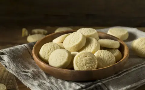 Una ciotola di legno piena di deliziosi biscotti senza uova, perfetti per una pausa dolce.