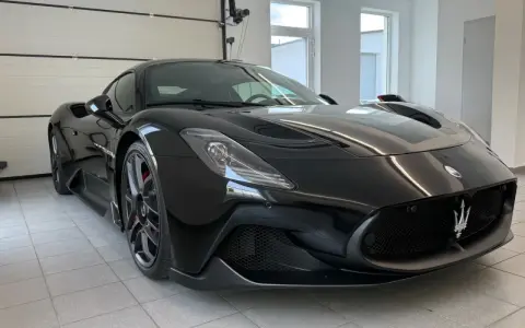 Czarny Maserati MC20 w garażu, widok z przodu.