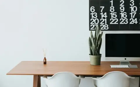 Escritorio moderno con ordenador, planta y calendario. Ideal para organizar tus aplicaciones de escritorio en la nube.