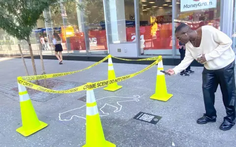 Ein Mann scannt mit seinem Handy einen QR-Code neben einer Kreideumriss-Leiche. Ein cleveres Guerilla-Marketing-Event.