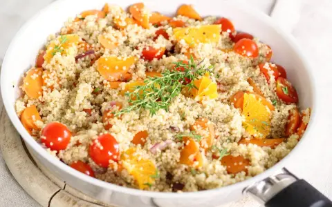Bunter Quinoa-Salat mit Karotten, Tomaten und Orange. Ein Beweis, dass ist quinoa gesund und lecker ist.