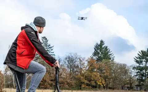 Mann mit Drohne im Flug, die der Spielzeugrichtlinie entspricht.