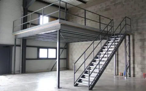 Escalier métallique menant à une création mezzanine dans un entrepôt. Structure industrielle fonctionnelle.