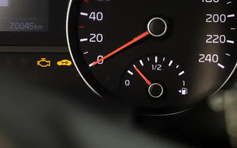 Armaturenbrett mit leuchtendem Motor-Zeichen und Schlüssel-Symbol. Der Kilometerstand zeigt 70045 km.