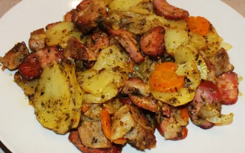 Pyszne duszonki z piekarnika: ziemniaki, kiełbasa i marchewka, doprawione ziołami.