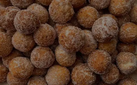 Un mucchio di dolci tipici di Tropea, palline fritte e cosparse di zucchero, invitano ad un assaggio goloso.
