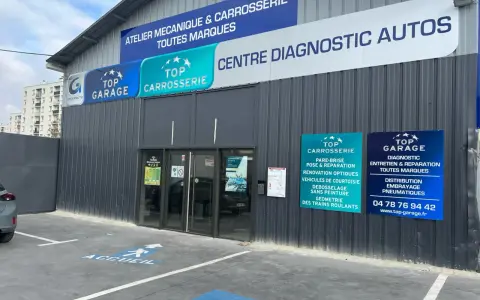 Façade d'un centre automobile avec des panneaux "Top Garage", "Top Carrosserie" et "Centre Diagnostic Autos".