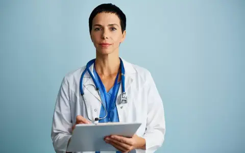 Medico con camice bianco e stetoscopio, appunti su cartella clinica. Ricerca sulla sindrome di Laron.