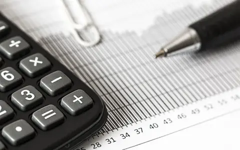 Calculadora y bolígrafo sobre gráficos. El modelo 309 para que sirve se puede deducir de estos elementos de contabilidad.