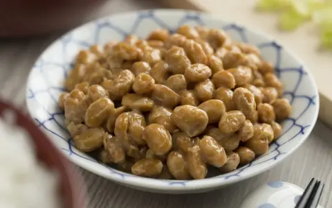 Nattokinaza na co pomaga? Miseczka sfermentowanej soi, czyli natto, z charakterystyczną nitkowatą konsystencją.