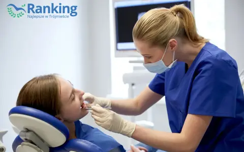Dentystka w masce bada zęby pacjentki w gabinecie stomatologicznym.