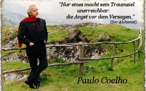 Mann mit rotem Schal und Anzug steht auf einem Hügel mit Zitat von Paulo Coelho.