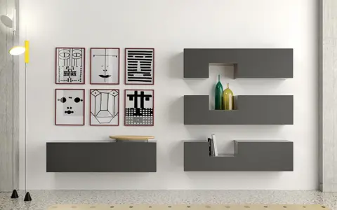 Parete con sei stampe astratte, mensole **Minottitalia** grigie con bottiglie e libri, lampada da terra.