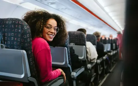 Smiling woman on a discount airlines european flight. She's happy to be traveling affordably.