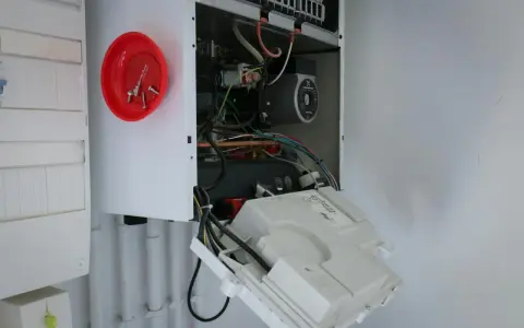 Ouvert pour l'entretien chaudière gaz obligatoire, on voit le circuit électrique et la pompe.