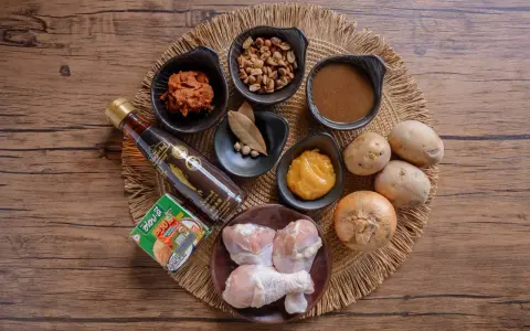 Zutaten für ein Massaman Curry Paste Rezept: Hähnchenschenkel, Kokosmilch, Erdnüsse, Kartoffeln, Zwiebel, Fischsauce, Currypaste und Gewürze.
