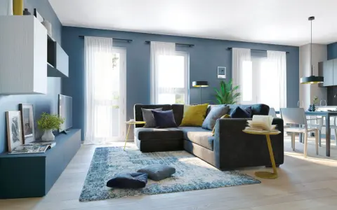 Un soggiorno moderno con divano angolare grigio scuro, cuscini blu e gialli, tappeto blu e bianco. Le pareti blu creano un'atmosfera rilassante, dimostrando che blu e grigio stanno bene insieme.