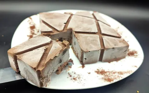 Un delizioso semifreddo al cioccolato, tagliato a cubetti e spolverato con cacao, pronto per essere gustato.