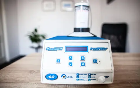 Urządzenie QuinTron BreathTracker do analizy oddechu na stole.