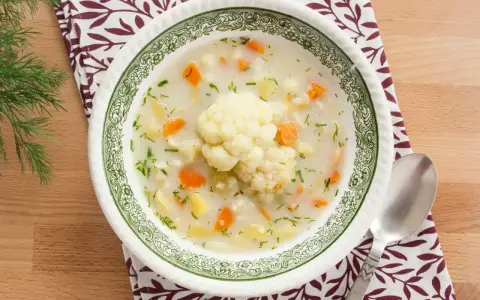 Aksamitna zupa kalafiorowa jak u babci, z kawałkami ziemniaków, marchewki i różyczką kalafiora. Podana z koperkiem.