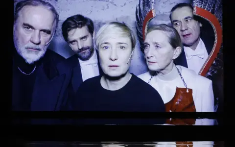 Kazimierz, reżyser i aktor teatralny, w otoczeniu aktorów na scenie.