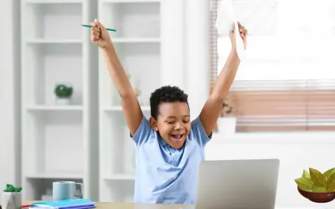 Niño celebra con un lápiz y papel, ¡cosas que dan suerte para un examen!