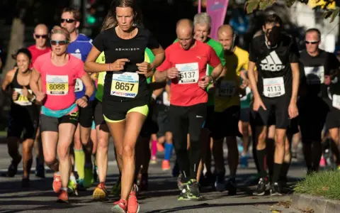 Löpare i Stockholm Halvmarathon kämpar för ett rekord. En kvinna med nummer 8657 leder loppet.