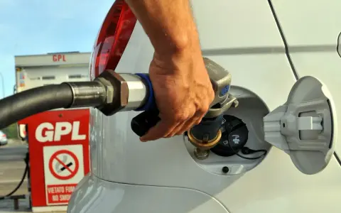 Rifornimento GPL in autostrada. Mano che inserisce la pistola nel serbatoio dell'auto.