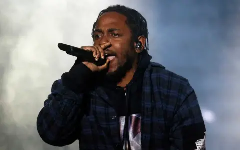 Kendrick Lamar, way out west, sjunger i en rutig skjorta med en mikrofon i handen.