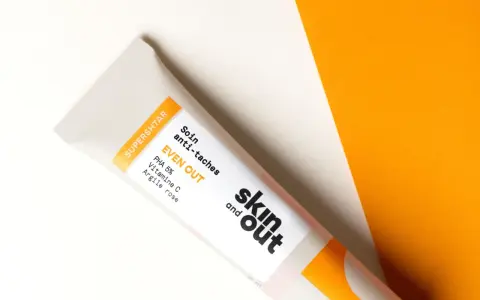 Tube de soin "EVEN OUT" de Skin and Out, contenant de la vitamine C, idéal pour lutter contre l'acné et les taches.