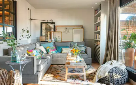 Salones muy pequeños con encanto: sofá gris, cojines coloridos, alfombra étnica, mesa de madera rústica y plantas.