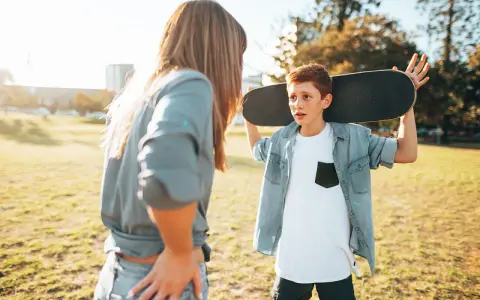 Ein Junge mit einem Skateboard über der Schulter spricht mit einer Frau. Die **Adoleszenz** ist eine spannende Zeit voller Entdeckungen.