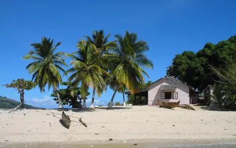 Piękna plaża z palmami i domkiem, idealne miejsce na wakacje. Zastanawiasz się, ile się leci na Madagaskar?