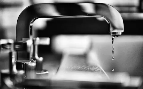 Gouttes d'eau tombant d'un robinet, évoquant la dureté de l'eau à Lyon.