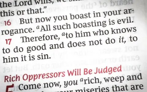 Close-up of a Bible page, showing text about the sin of omission: "to him who knows to do good and does not do it, to him it is sin.