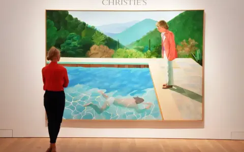A woman in red observes David Hockney's iconic pool painting at Christie's, a testament to his significant david hockney net worth.